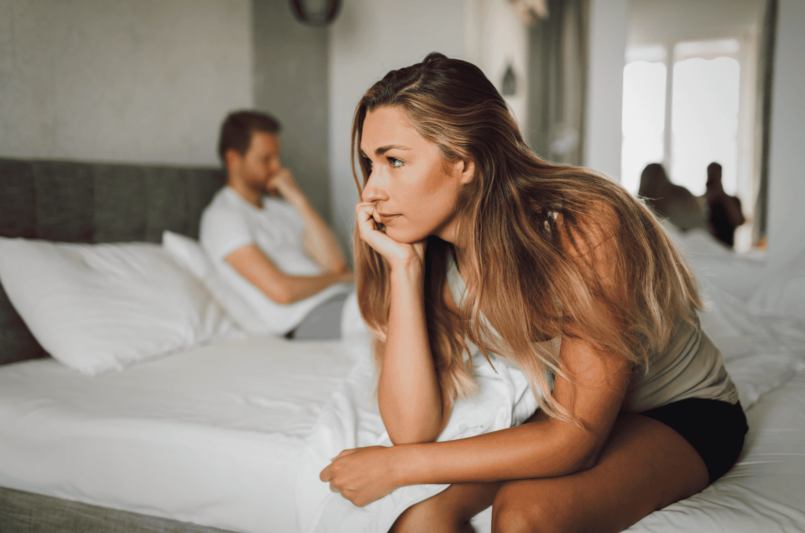 Woman on bed wondering if she has ROCD or is in the wrong relationship.